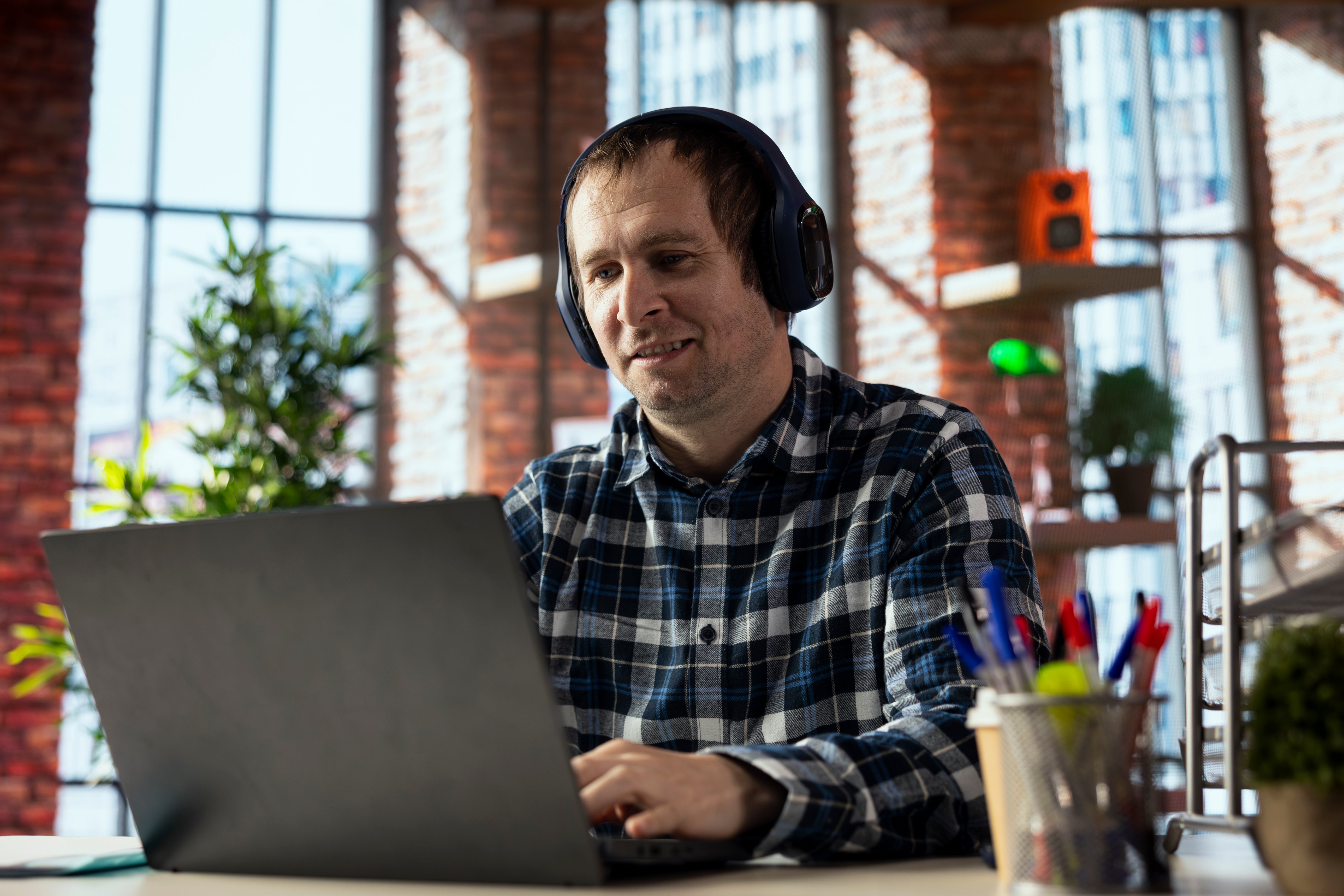 empleado-remoto-sonriente-con-auriculares-en-la-oficina-en-casa